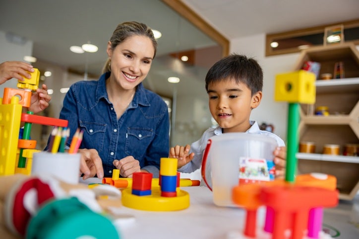 Child happily playing with colored balls during an occupational therapy session at Daisy Kids Care in Houston, TX